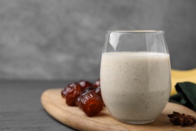 Photo of Glass of delicious date smoothie and dried fruits on table, closeup. Space for text