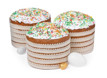 Photo of Traditional Easter cakes with sprinkles and decorated eggs on white background
