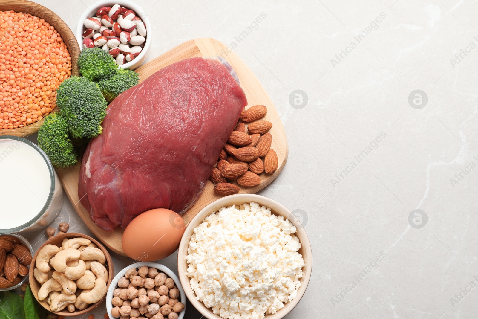 Photo of Set of natural food high in protein and space for text on light background, top view