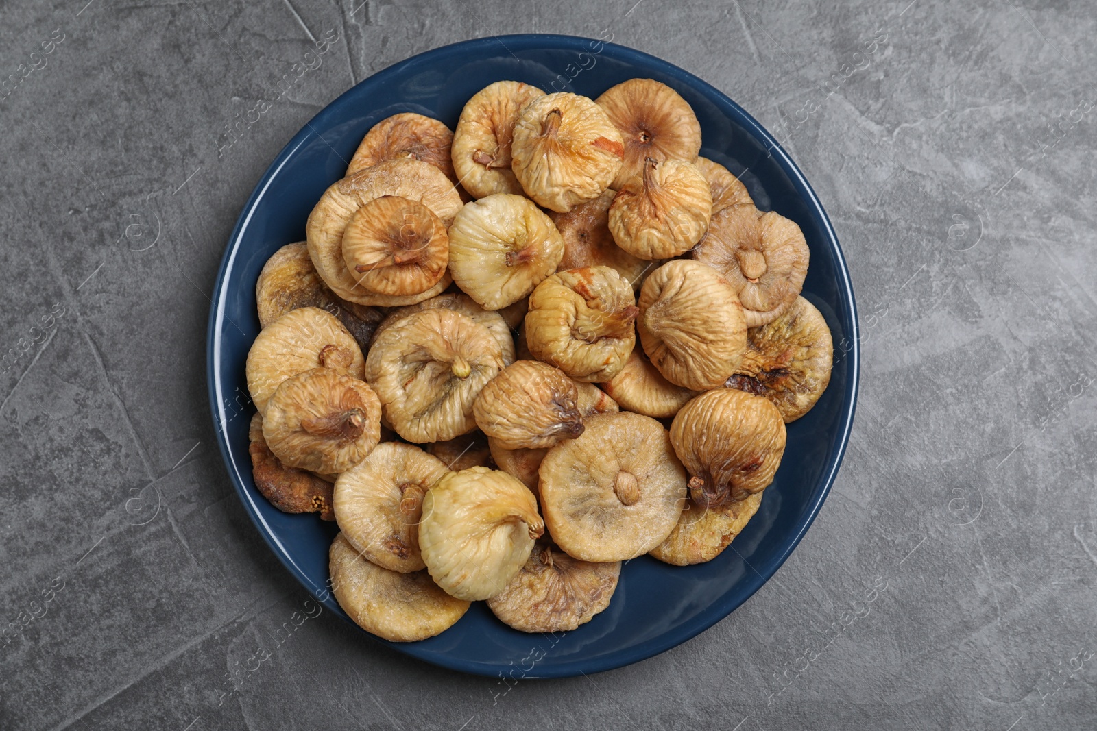 Photo of Tasty dried figs on grey table, top view