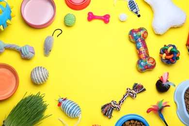 Photo of Different pet toys and feeding bowls on yellow background, flat lay. Space for text