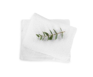 Photo of Terry towels and eucalyptus branch isolated on white, top view