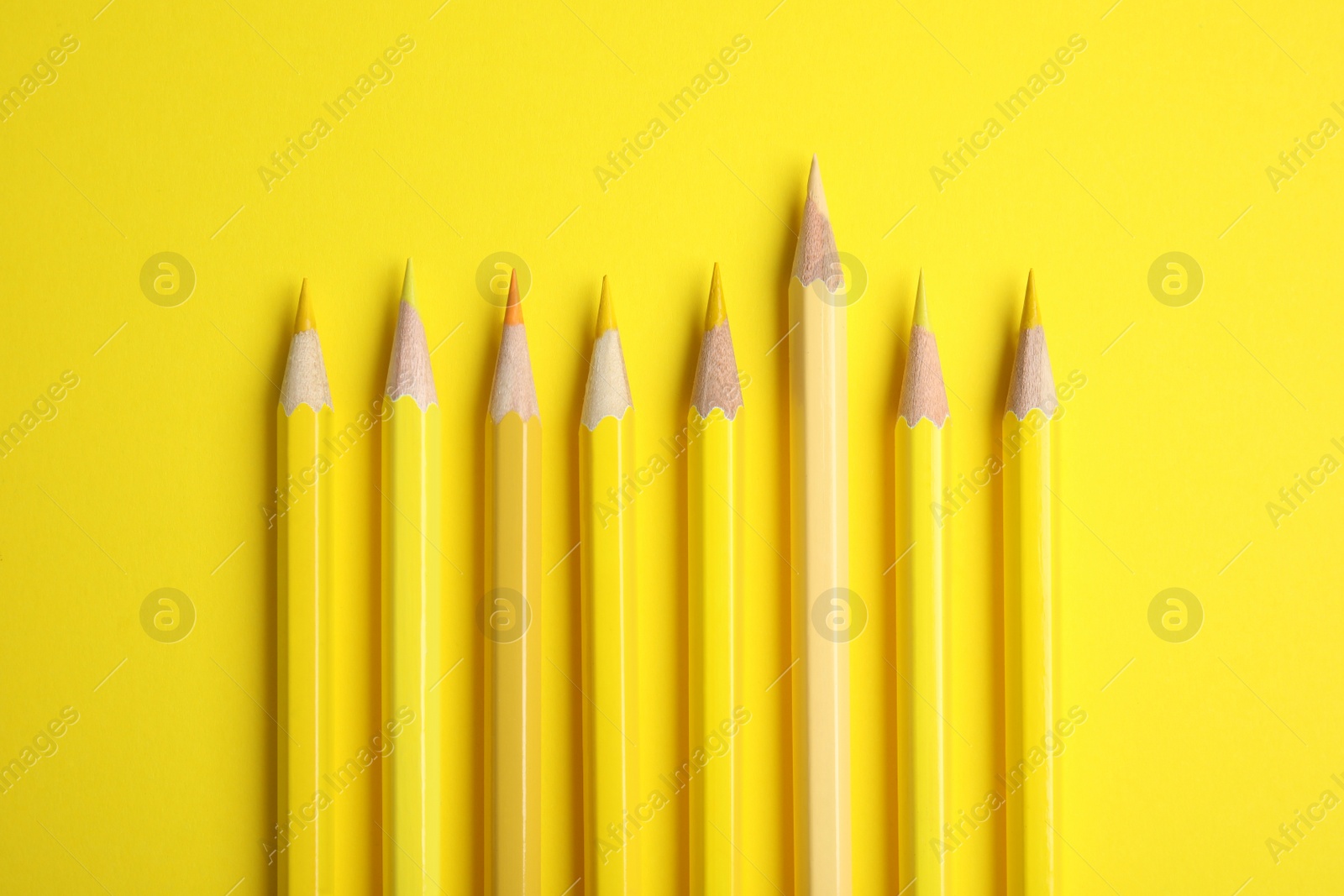 Photo of Flat lay composition with color pencils on yellow background