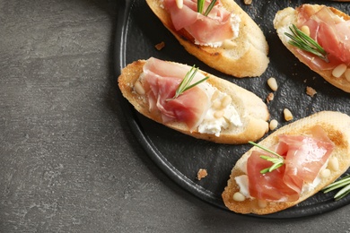 Flat lay composition with tasty bruschettas on grey table. Space for text