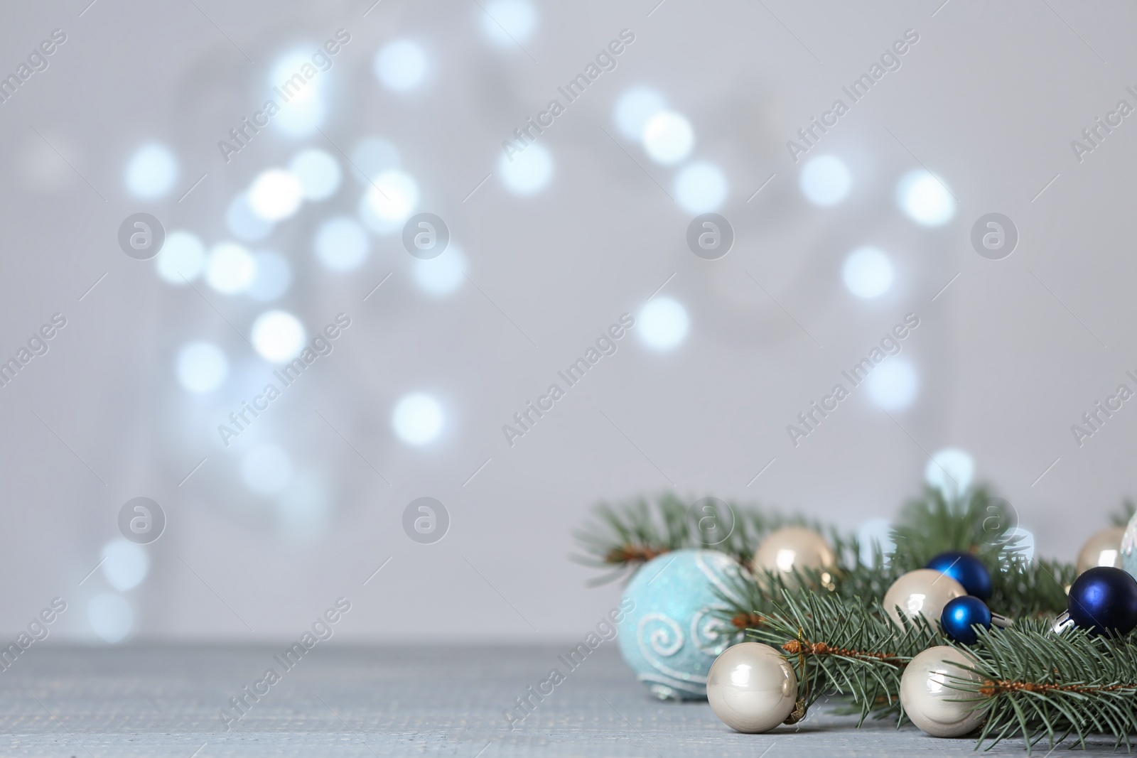 Photo of Christmas decoration on table against blurred lights. Space for text