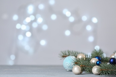 Photo of Christmas decoration on table against blurred lights. Space for text