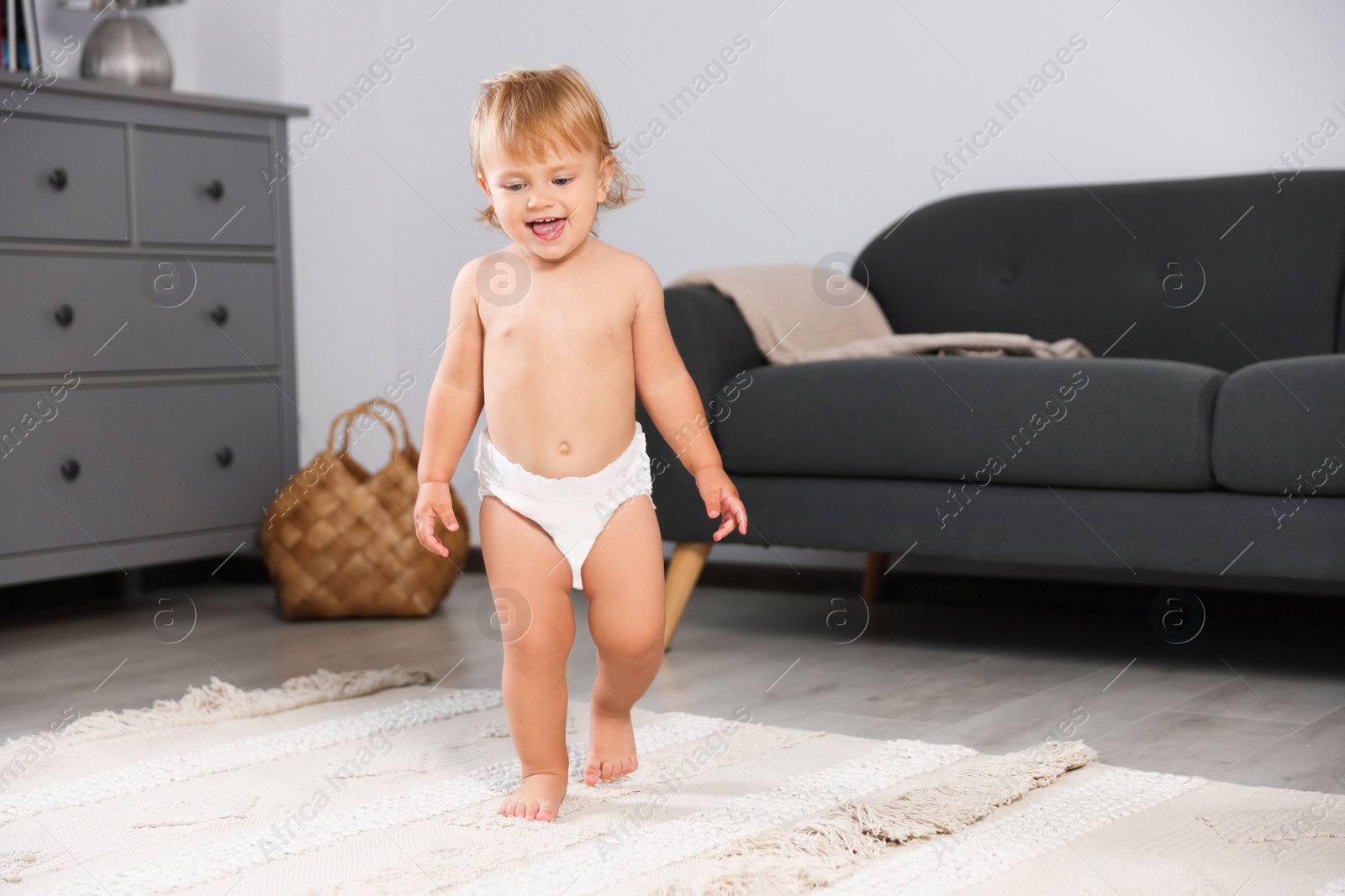 Photo of Cute baby learning to walk in living room