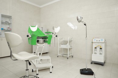 Modern gynecological office interior with examination chair and medical equipment