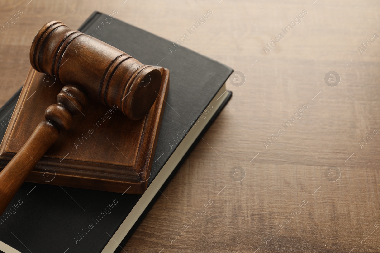 Photo of Law concept. Gavel and book on wooden table, closeup. Space for text