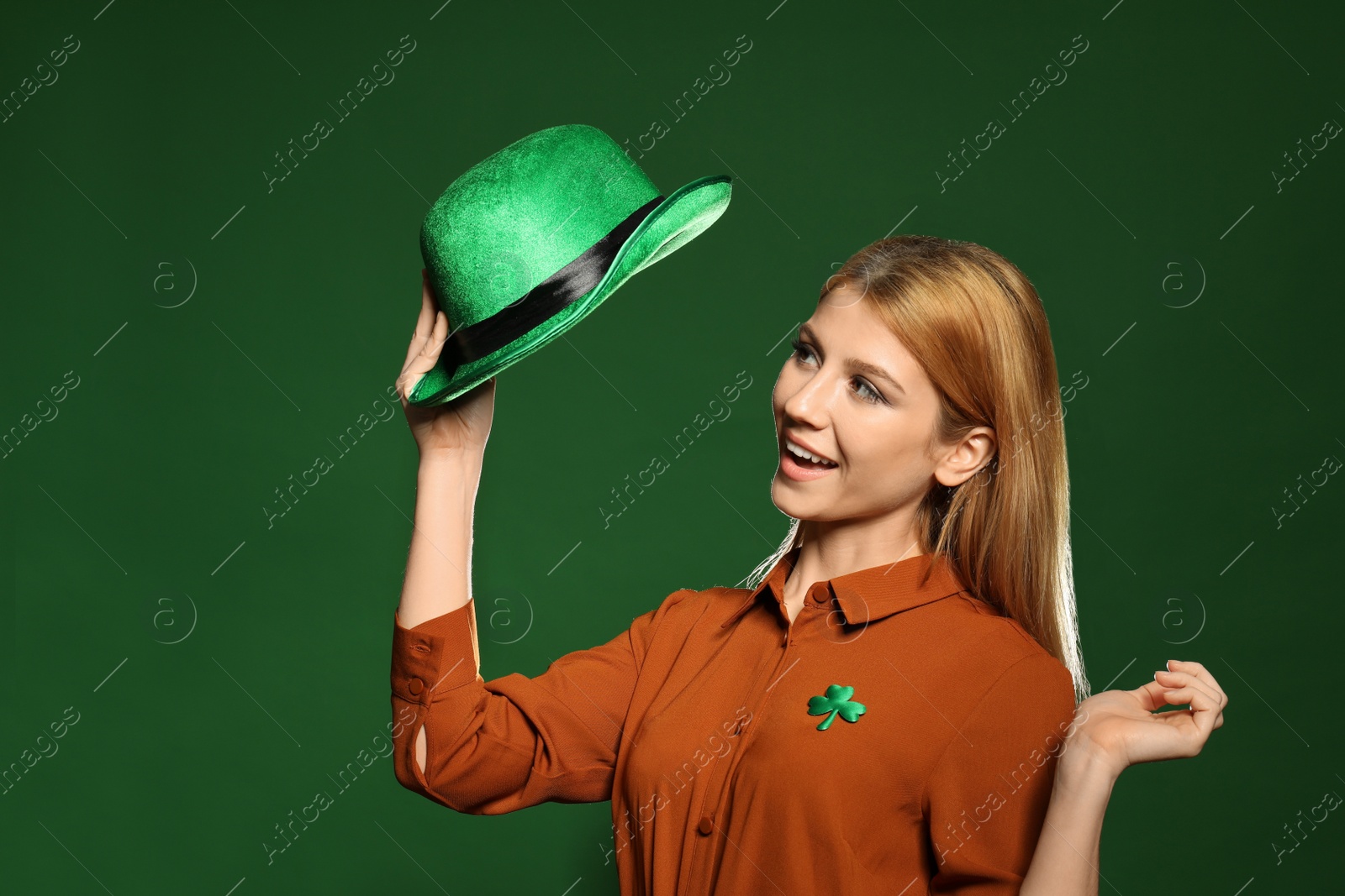 Photo of Young woman with green hat on color background. St. Patrick's Day celebration