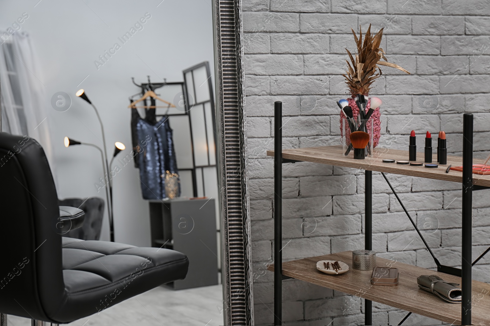 Photo of Comfortable chair near mirror and shelves in makeup room