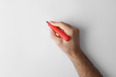 Photo of Man holding red marker on white background, top view