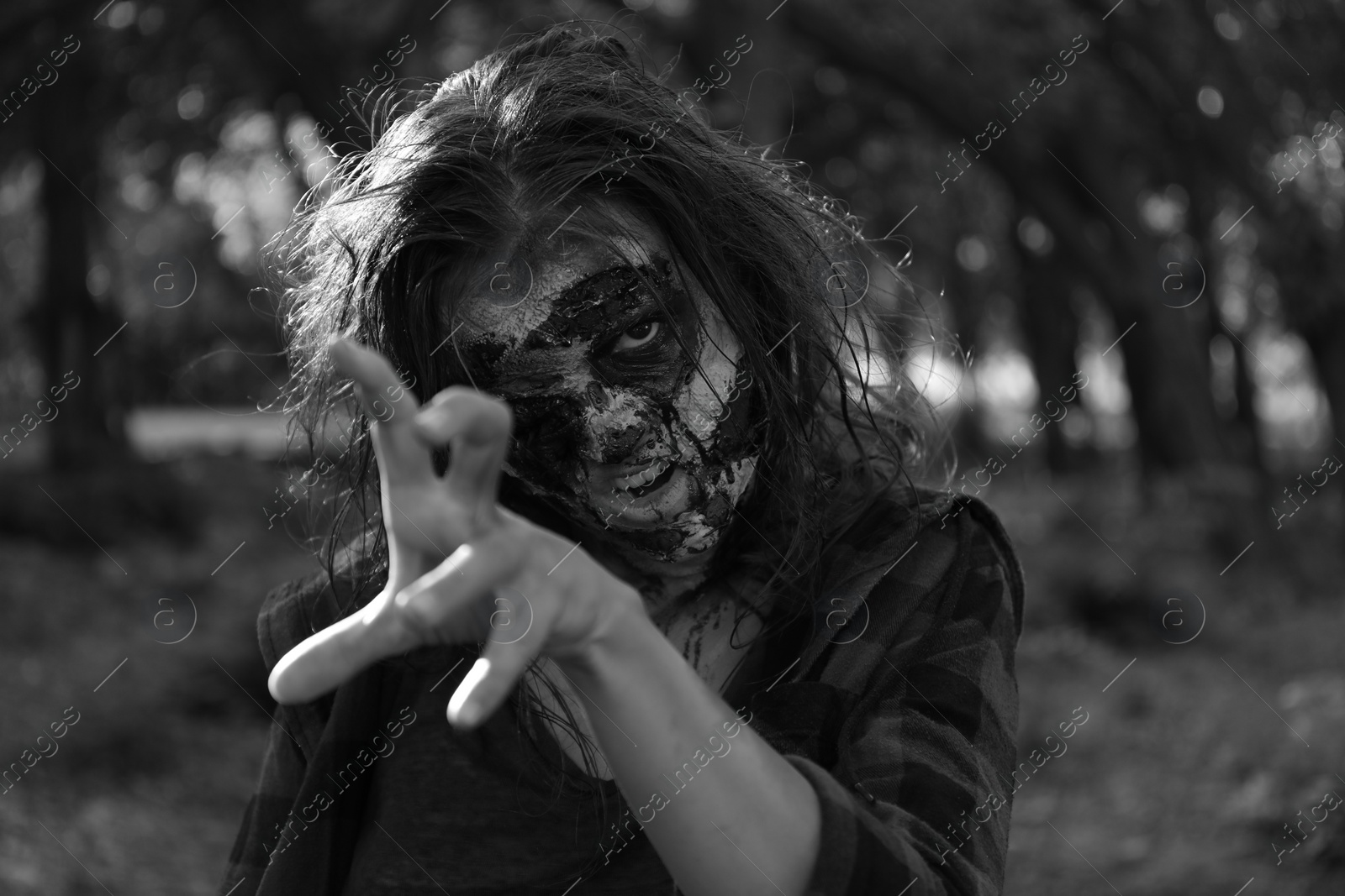 Photo of Scary zombie outdoors, black and white effect. Halloween monster