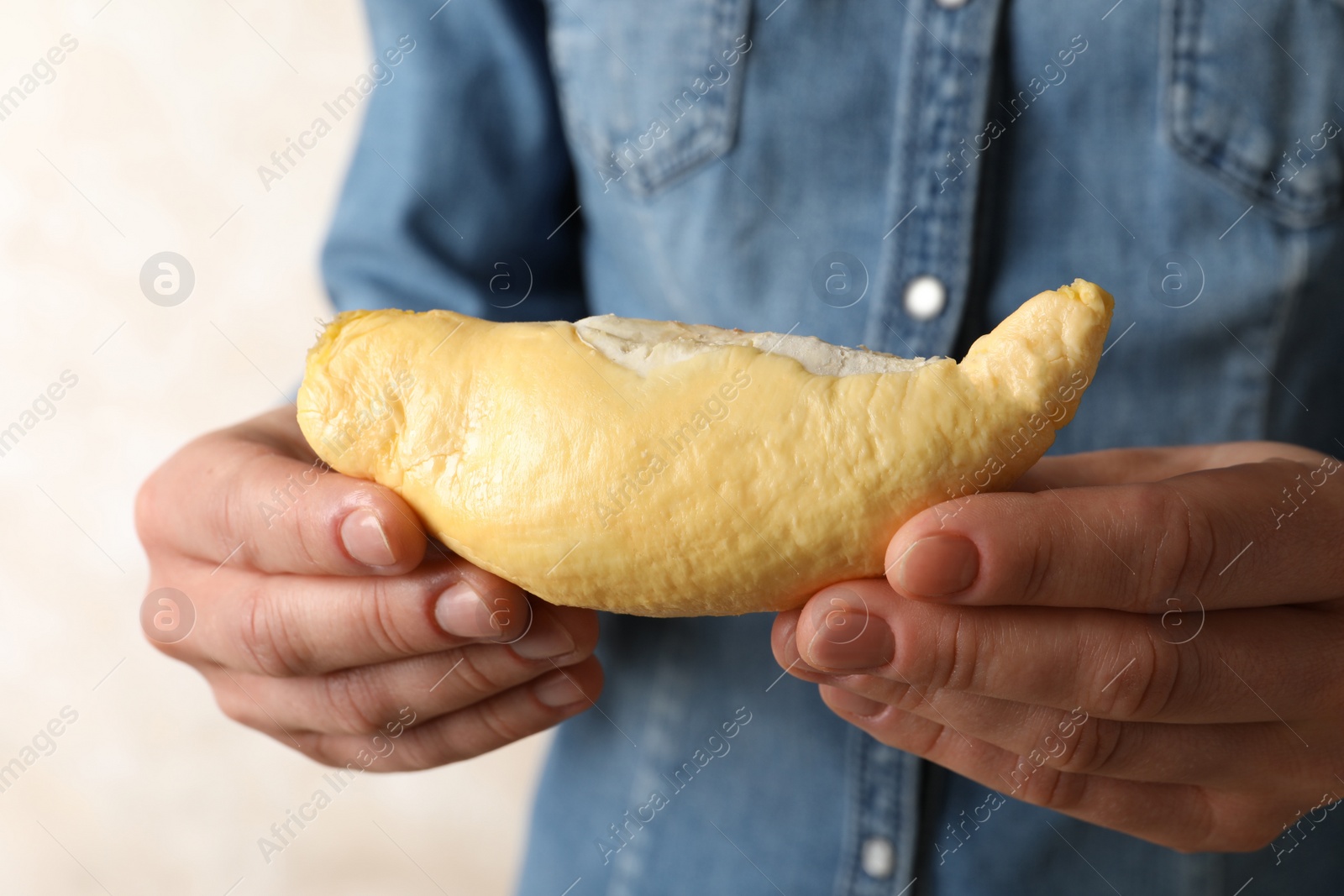 Photo of Woman holding peeled fresh ripe durian, closeup