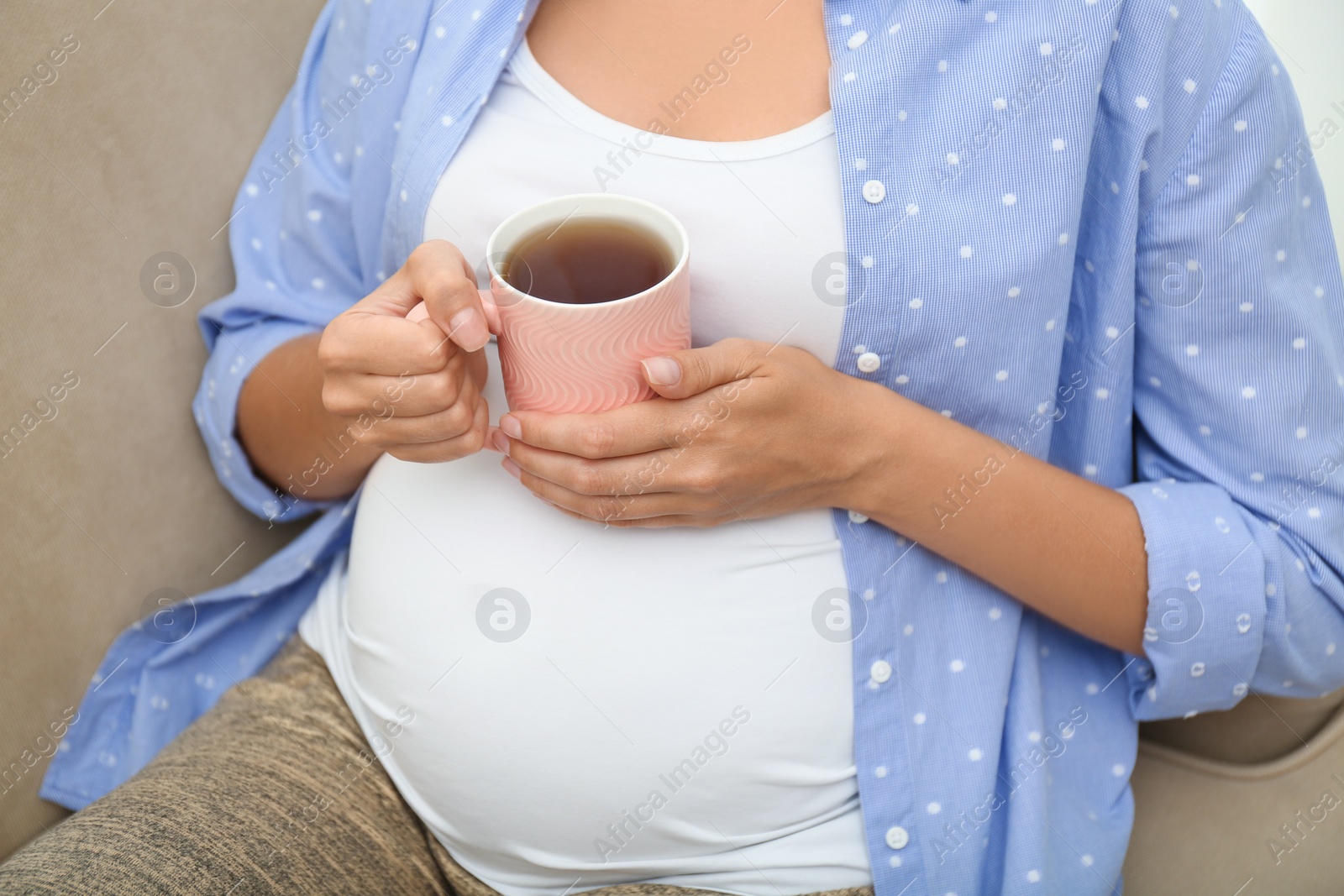 Photo of Pregnant woman drinking tea at home, closeup