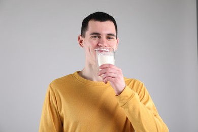 Photo of Milk mustache left after dairy product. Man drinking milk on gray background