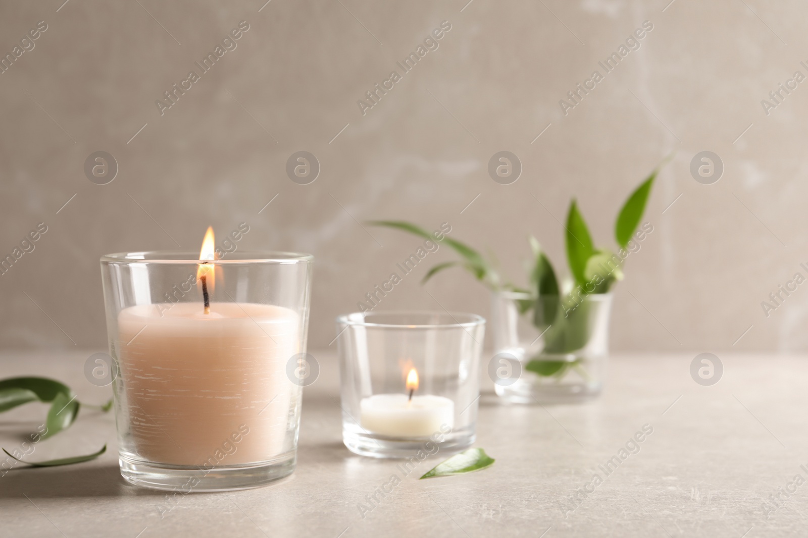 Photo of Burning wax candles in glasses on table