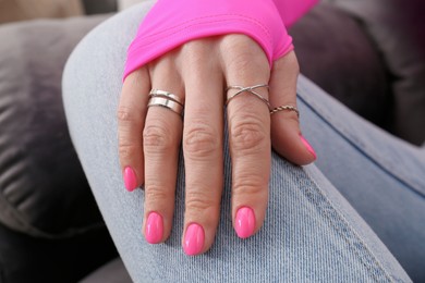 Photo of Woman showing manicured hand with pink nail polish, closeup