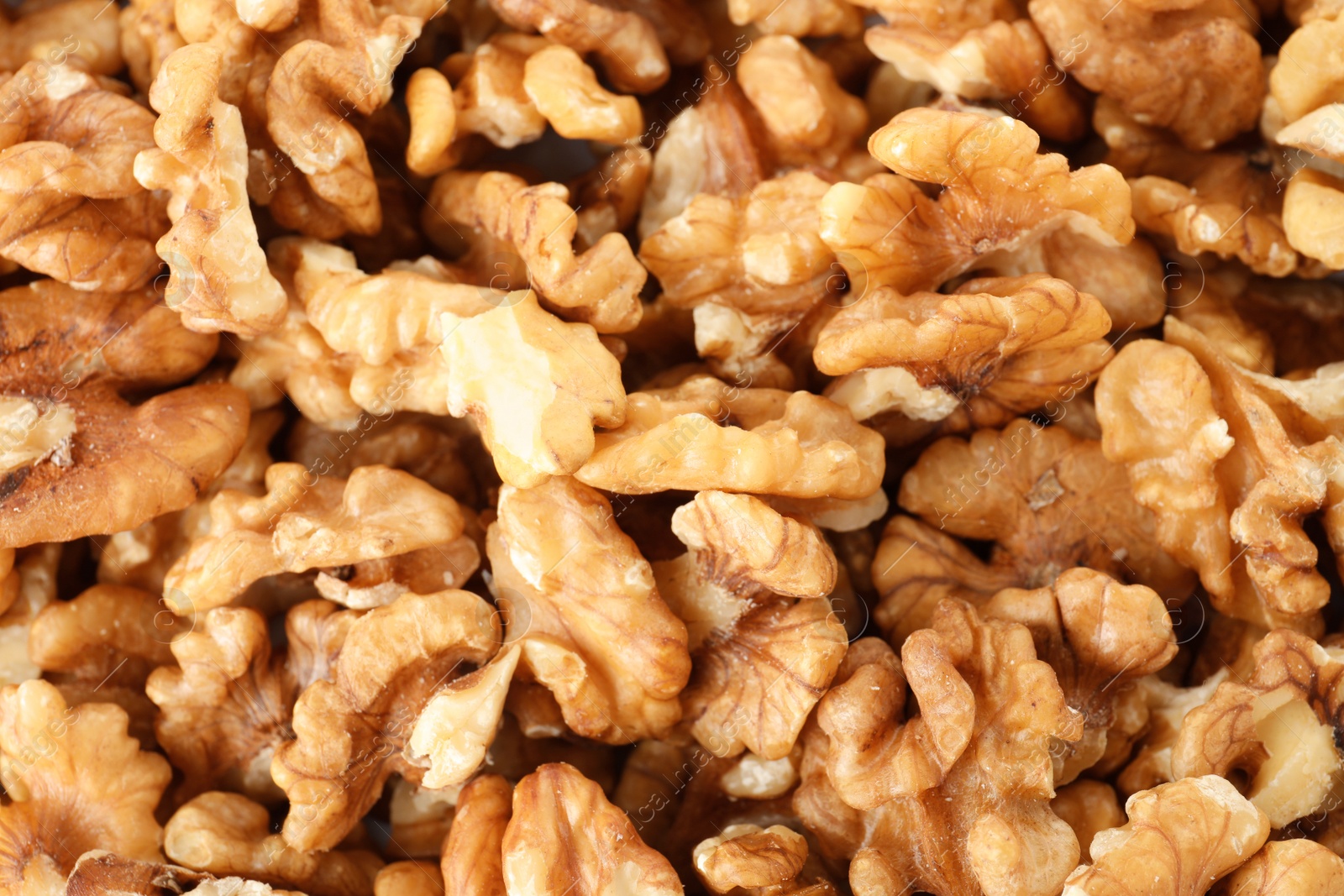 Photo of Many shelled walnuts as background, top view