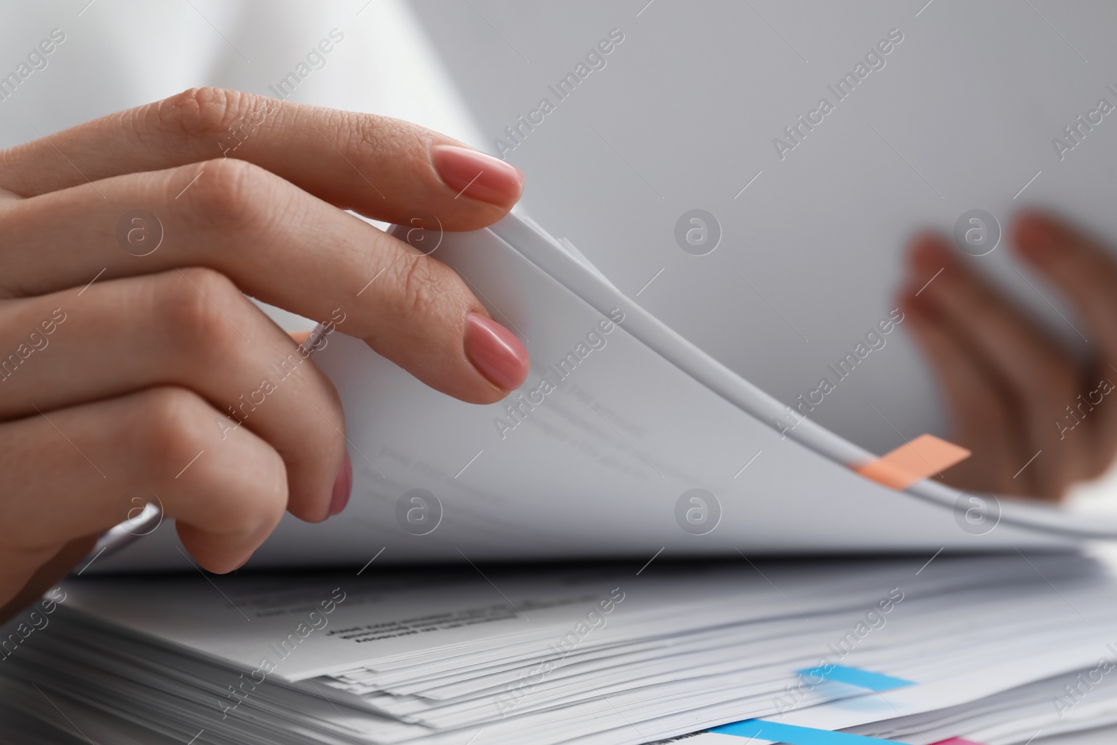 Photo of Woman reading documents at table in office, closeup