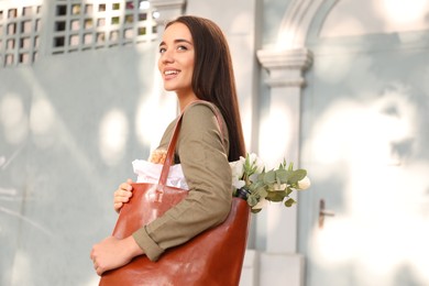 Young woman with leather shopper bag outdoors