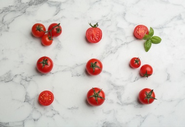 Photo of Flat lay composition with fresh cherry tomatoes and basil leaves on white marble table