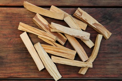 Many palo santo sticks on wooden table, flat lay