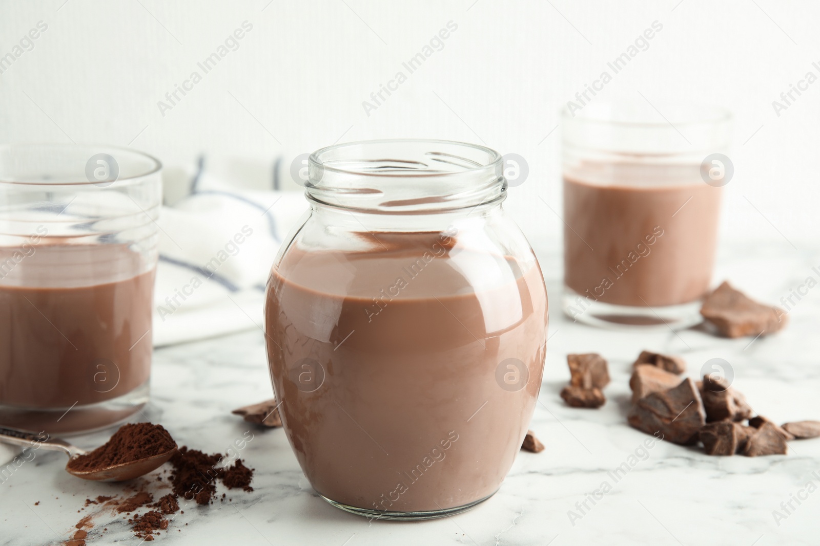 Photo of Glassware with tasty chocolate milk on marble table. Dairy drink