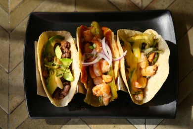 Photo of Delicious tacos with shrimps and vegetables on table, top view