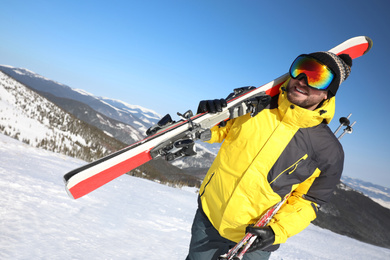 Photo of Young man with ski on hill. Winter vacation