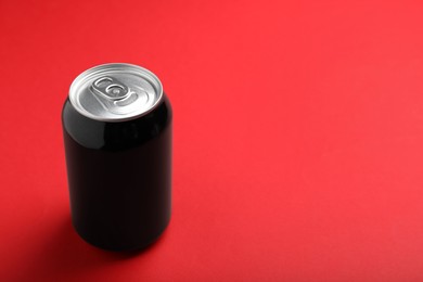 Photo of Black can of energy drink on red background. Space for text