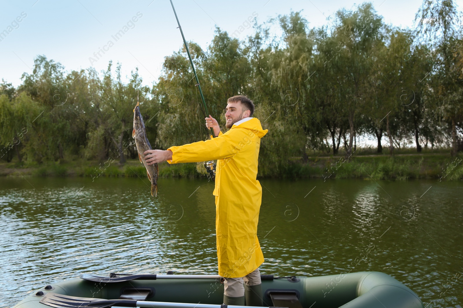 Photo of Man with rod and catch fishing from boat. Recreational activity