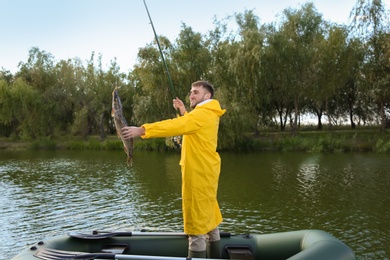 Man with rod and catch fishing from boat. Recreational activity