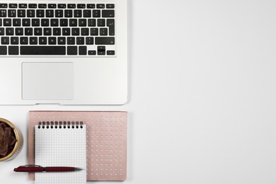 Photo of Modern laptop, notebooks, pen and houseplant on white background, flat lay. Space for text