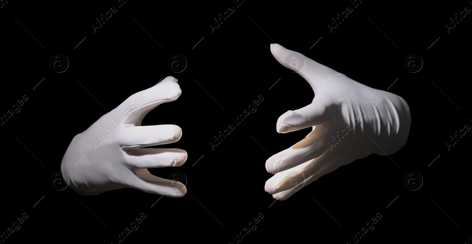 Photo of Magician holding something on black background, closeup