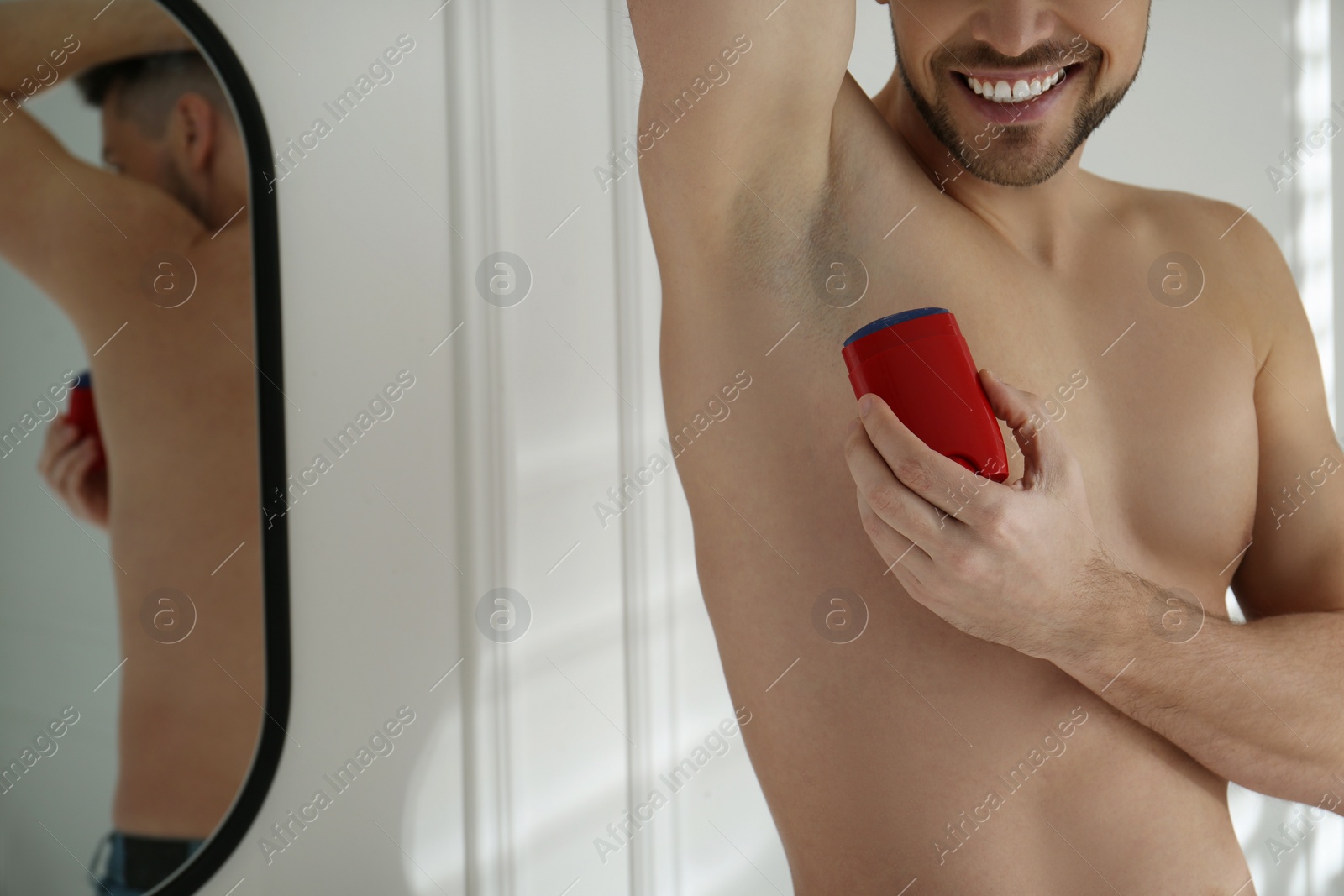 Photo of Man applying deodorant in bathroom, closeup. Space for text