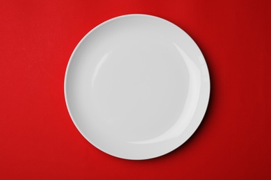 Clean empty plate on color background, top view