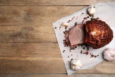 Photo of Cut delicious ham, spices and garlic on wooden table, flat lay. Space for text