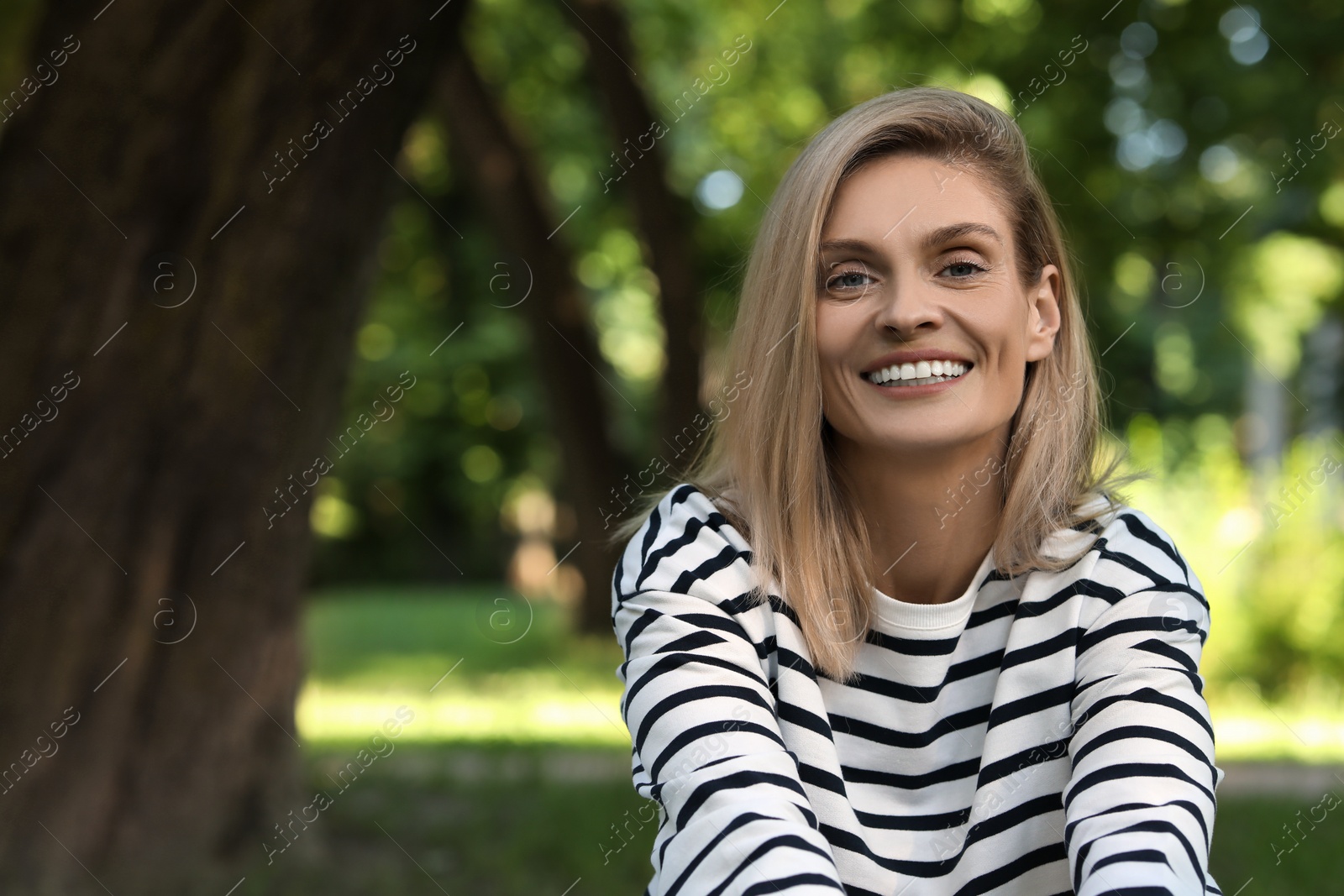 Photo of Portrait of happy woman in casual clothes outdoors. Space for text. Attractive lady smiling and posing for camera