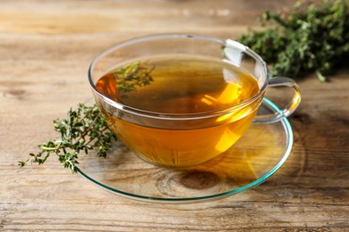 Aromatic herbal tea with thyme on wooden table