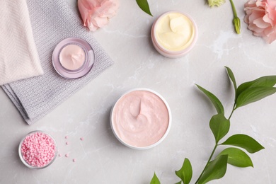 Photo of Flat lay composition with hand cream jars on light background