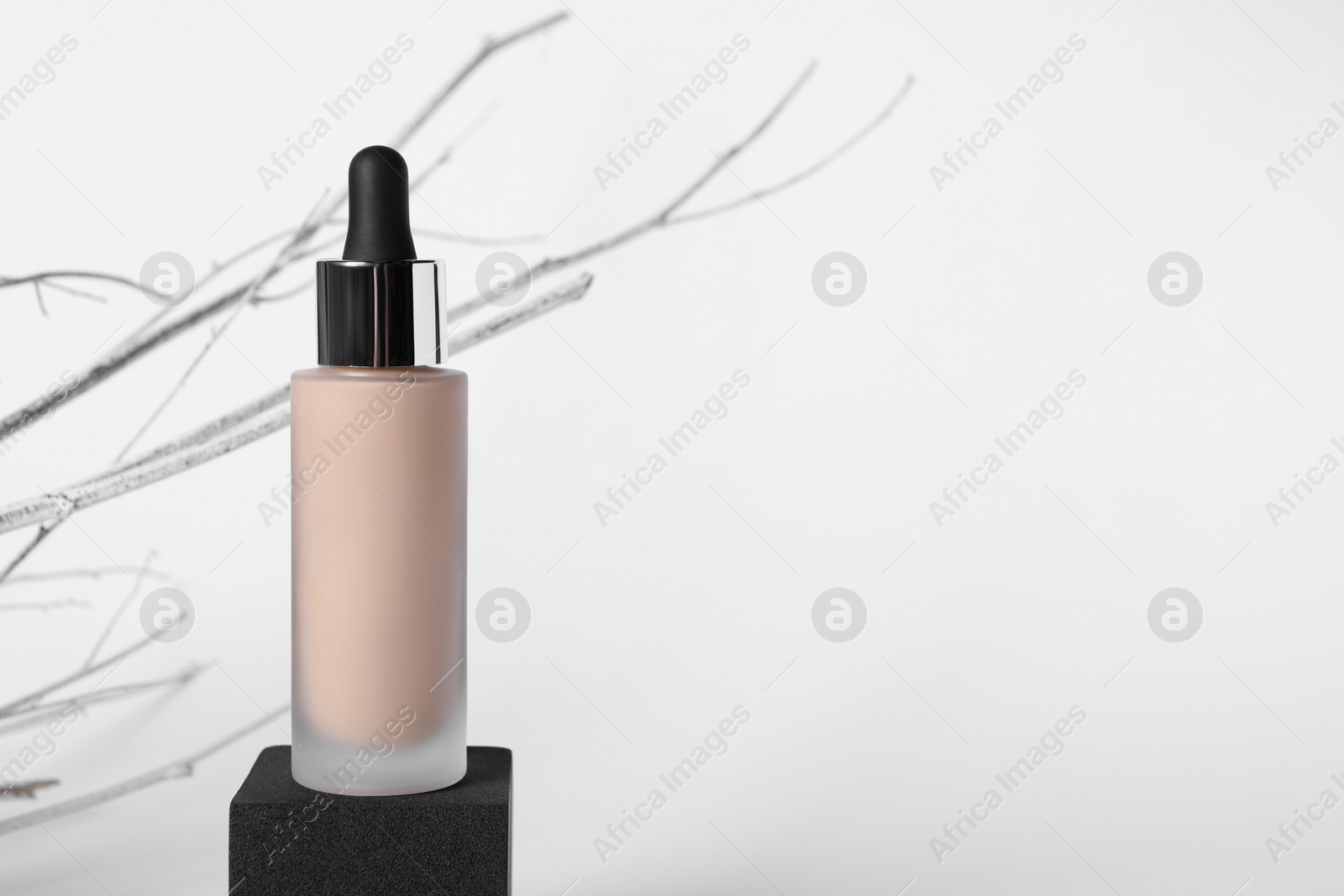 Photo of Bottle of skin foundation on white background, space for text. Makeup product