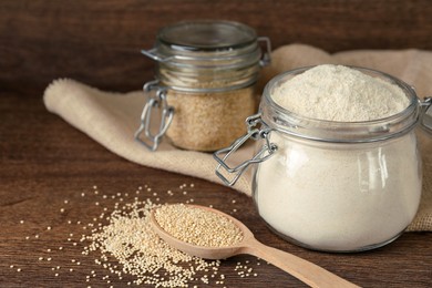 Photo of Jar with quinoa flour and seeds on wooden table