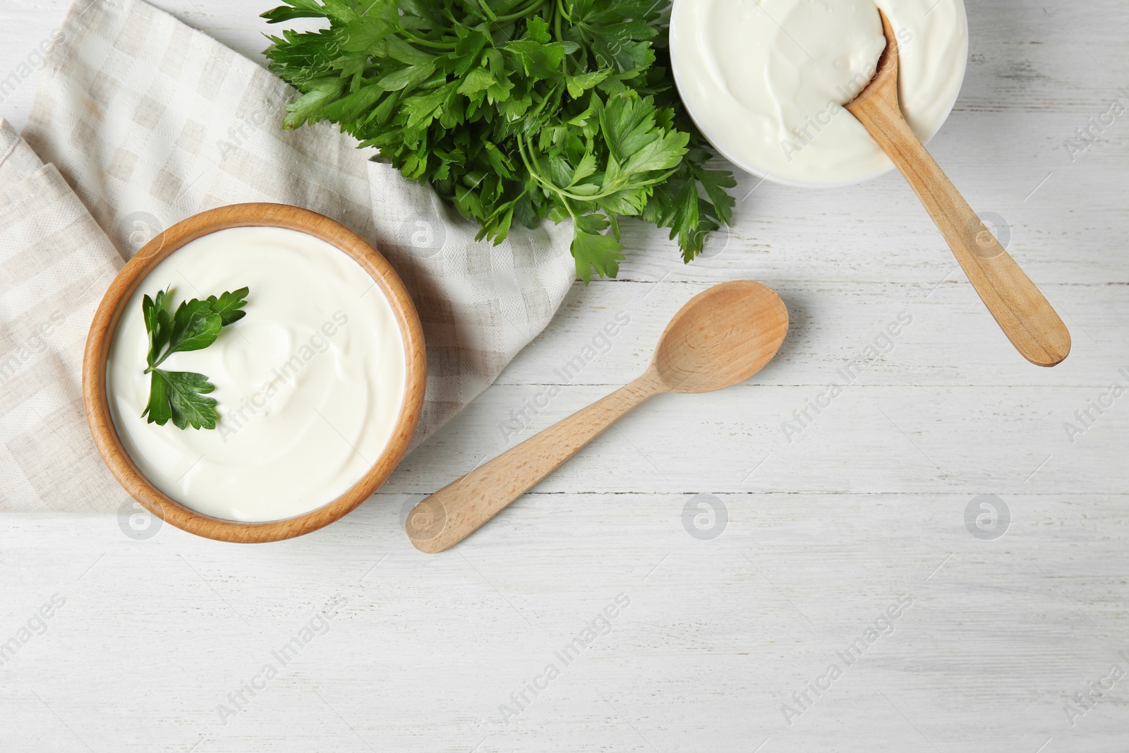 Photo of Flat lay composition with sour cream and parsley on white wooden table. Space for text