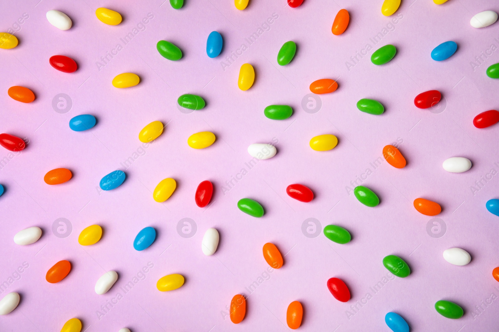 Photo of Flat lay composition with jelly beans on color background