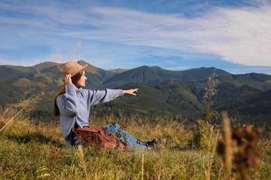 Photo of Young woman enjoying beautiful mountain landscape on sunny day