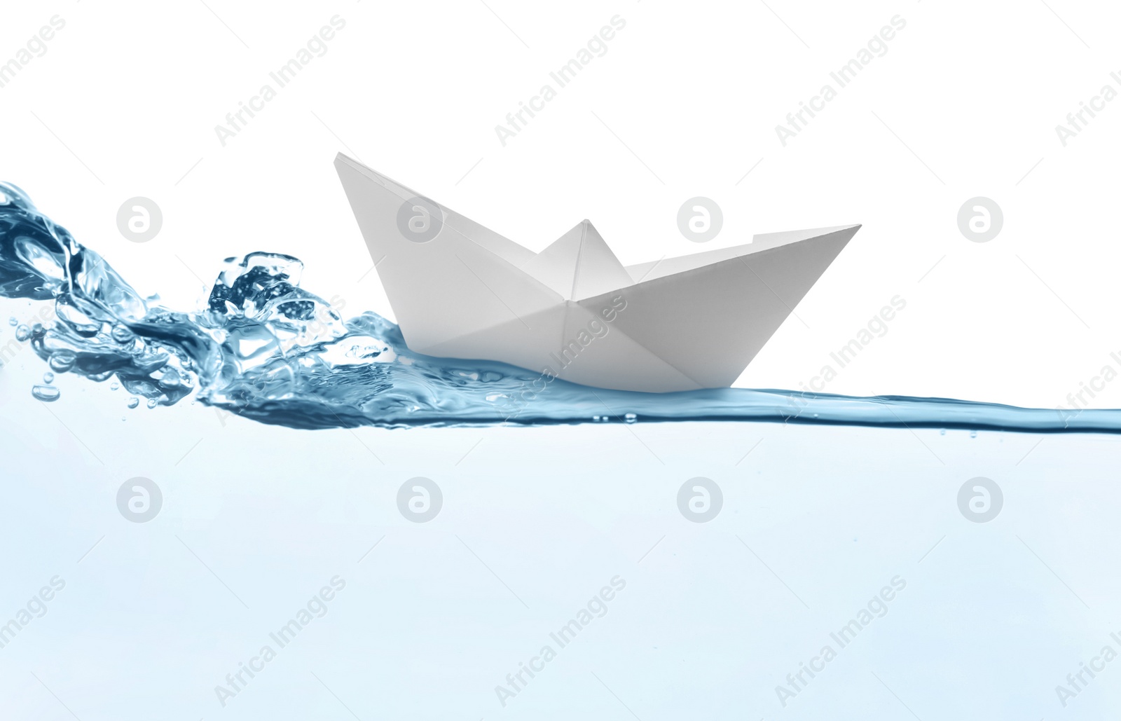 Image of Handmade paper boat floating on clear water against white background 