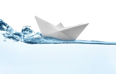 Image of Handmade paper boat floating on clear water against white background 