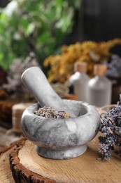 Photo of Mortar with pestle and lavender flowers on table, closeup. Medicinal herbs
