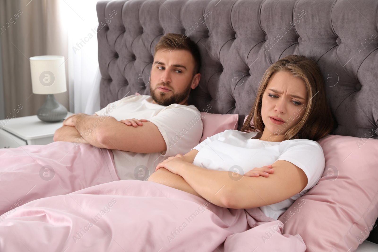 Photo of Young couple with relationship problems in bed at home